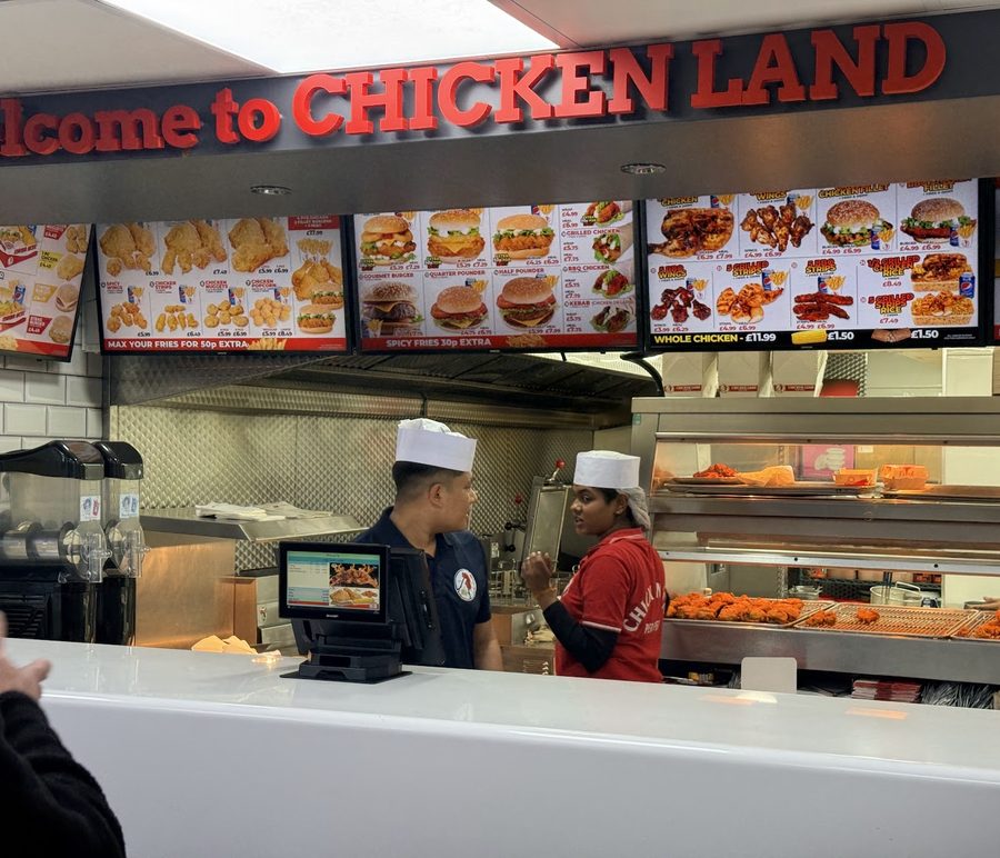 The service counter with staff working behind the lit menu boards